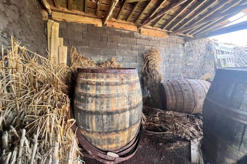 A rustic setting with a weathered barrel, straw, and a brick wall. 3