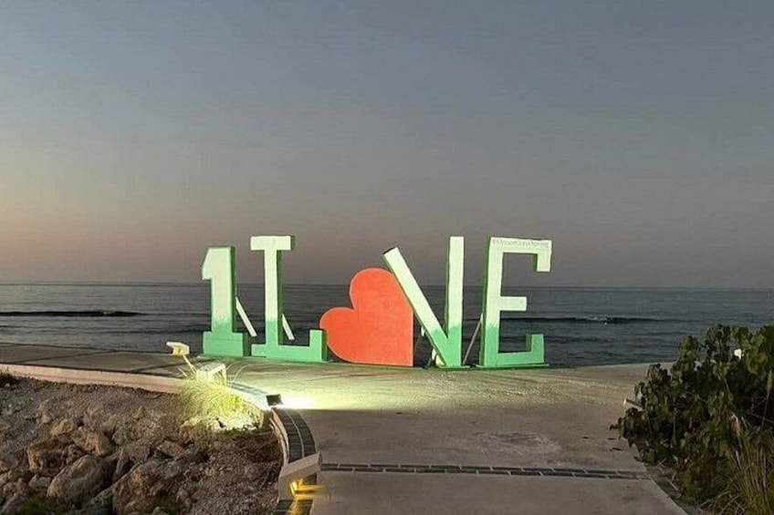 Une plage où sont inscrites en grandes lettres les mots « LOVE » et où l’on peut voir un symbole en forme de cœur. 3