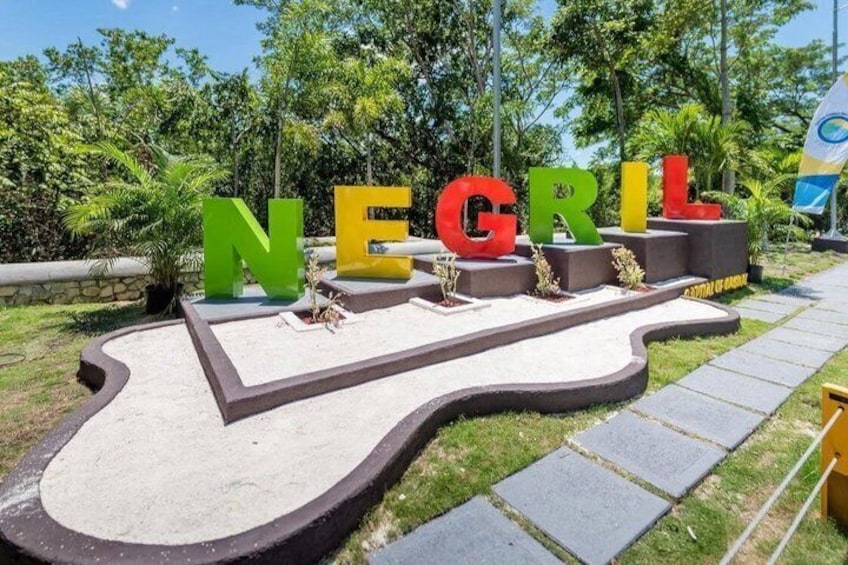 A pathway with the word 'NEGRIL' spelled out in large letters, surrounded by greenery. 3