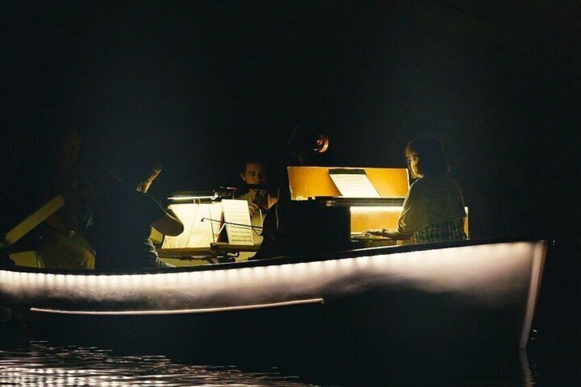A boat with people on board, a person playing a keyboard, and a person with a guitar. 5