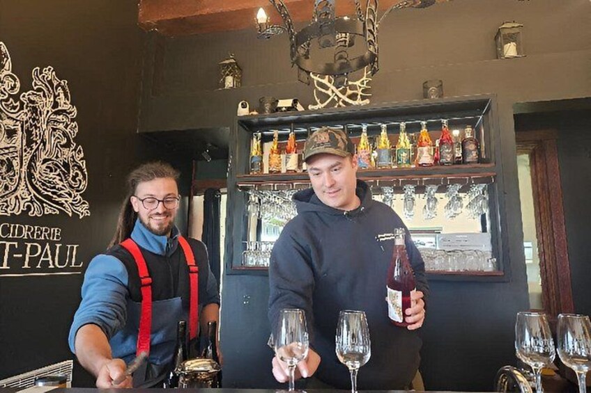 Two people at a bar, one pouring a drink into a glass. 2