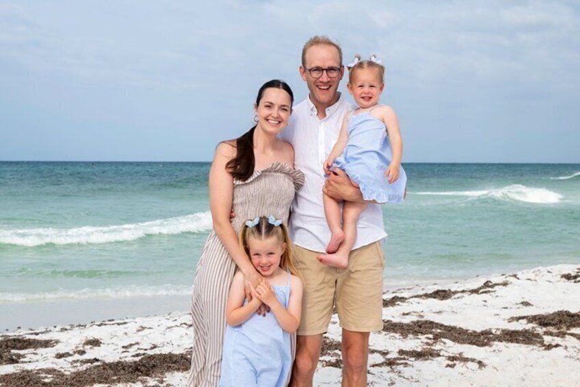 A family on a beach with ocean waves in the background. 4