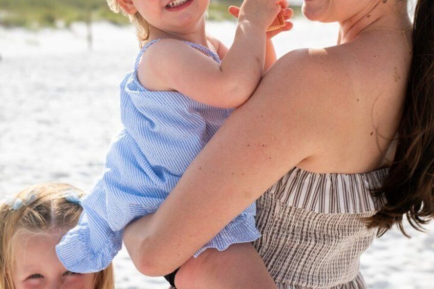 A person holding a child on a beach. 5