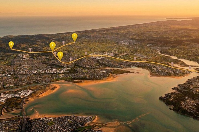 An aerial view of a coastal city with a river, marked locations, and a sunset. 1
