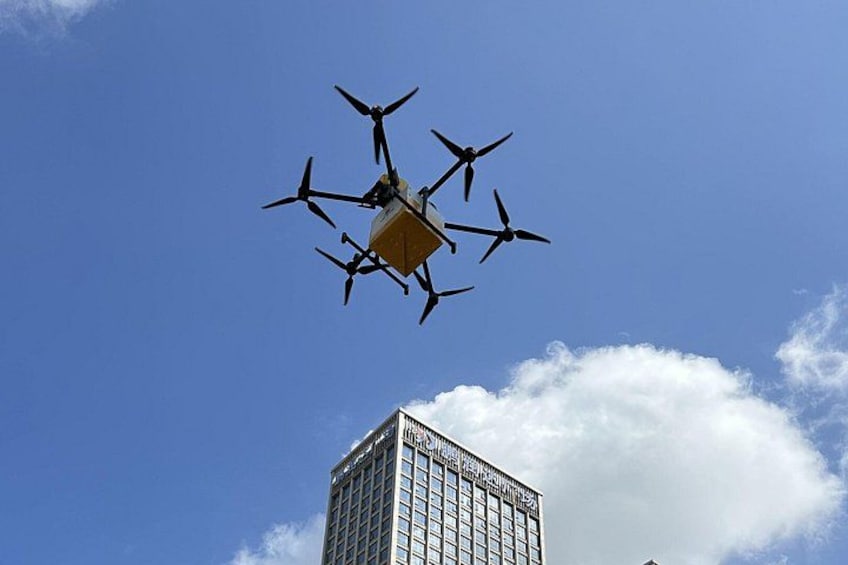 A drone flying in the sky with a building in the background. 1