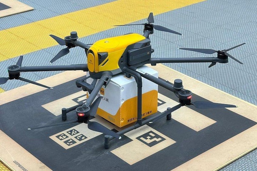 A drone with propellers on a landing pad marked with symbols. 2