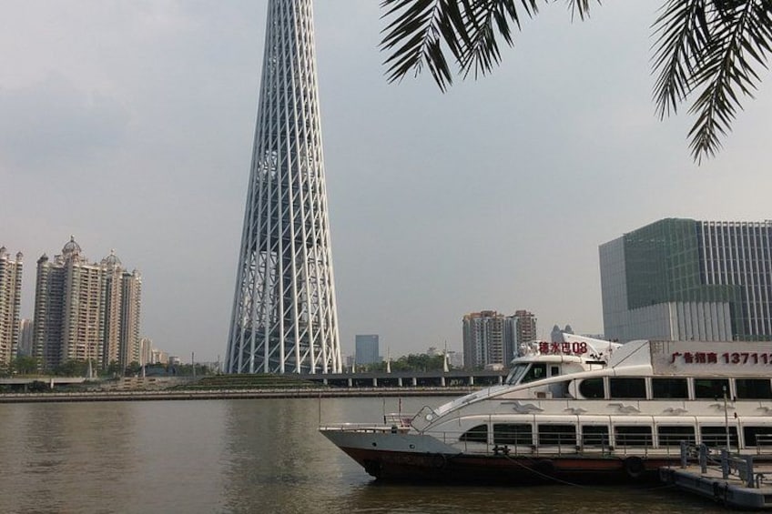 A river with a tall, slender tower and a boat. 1