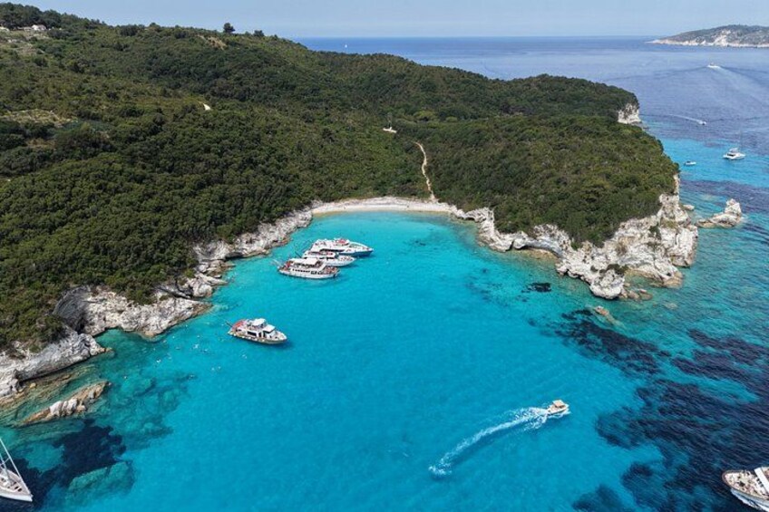 A coastal area with boats, a clear blue sea, and a green island. 2