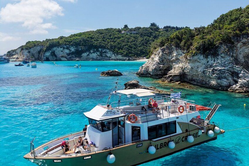 A boat named 'LBRO' on clear turquoise waters with rocky cliffs in the background. 3
