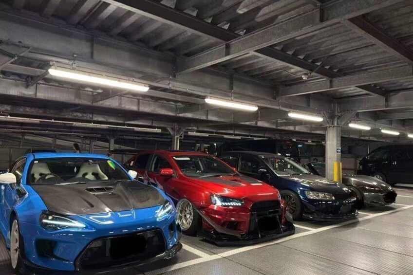 A multi-level underground parking garage with several sports cars parked. 4