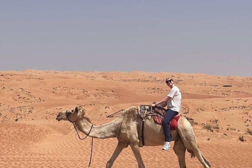 A person riding a camel in a desert landscape. 5