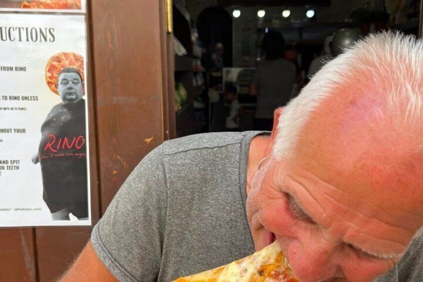 A person eating a large slice of pizza. 4