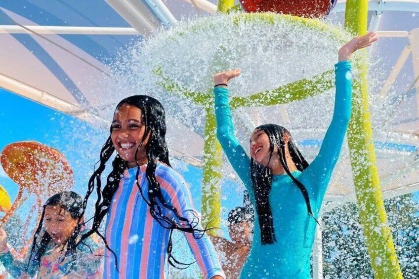 People playing in a water park with water jets and slides. 1