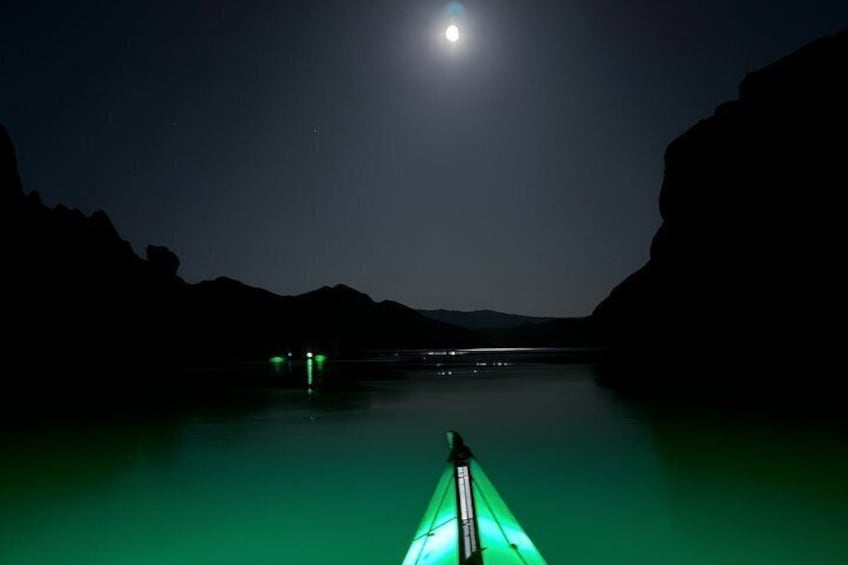 A nighttime kayaking scene with a moonlit sky and calm water. 5