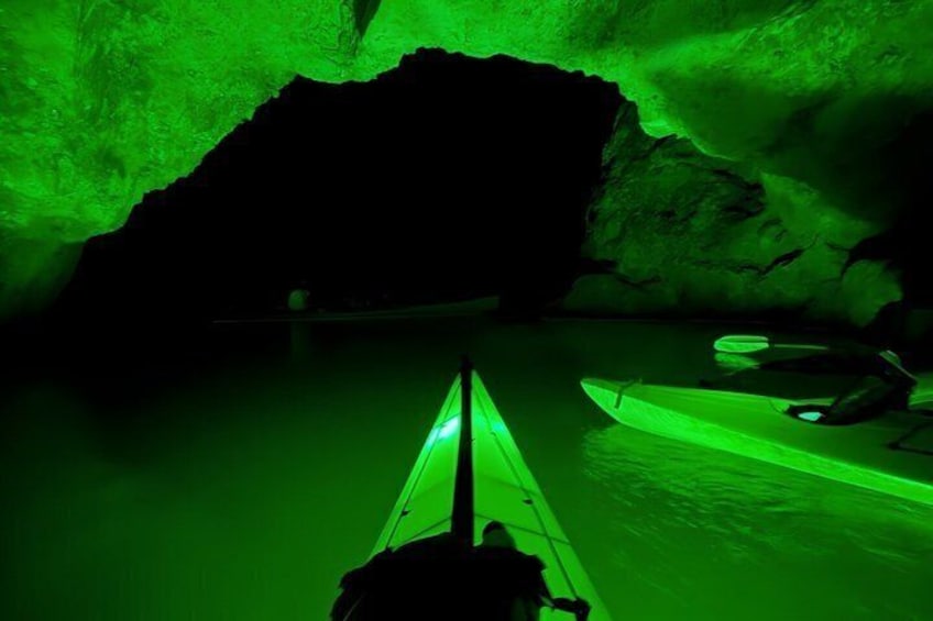 A kayak in a cave with green lighting. 1