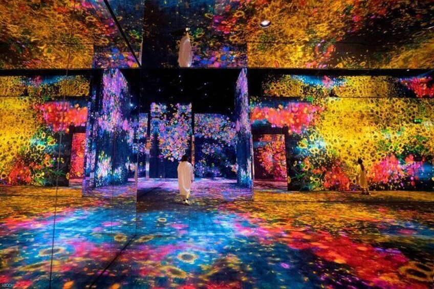 A colorful, abstract art installation with a central platform and vibrant patterns on the walls and floor. 3