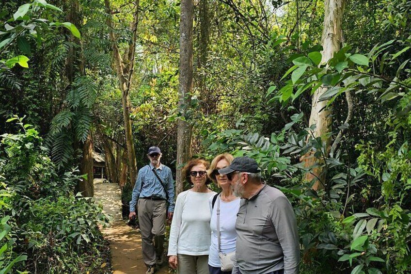 A group of people walking on a forest path surrounded by dense vegetation. 5