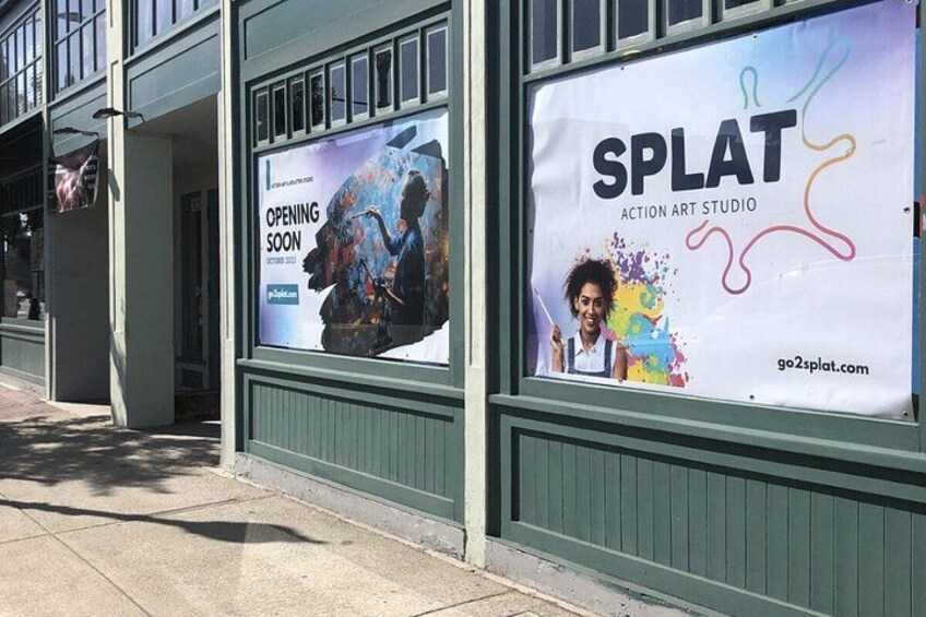 A storefront with a large poster advertising an art studio opening soon. 2