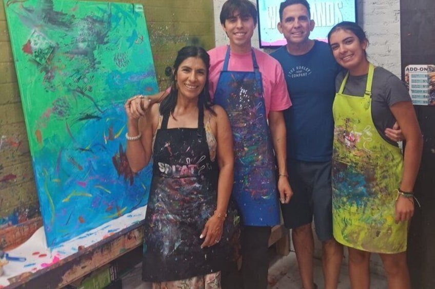 Four people standing in front of a large abstract painting. 4