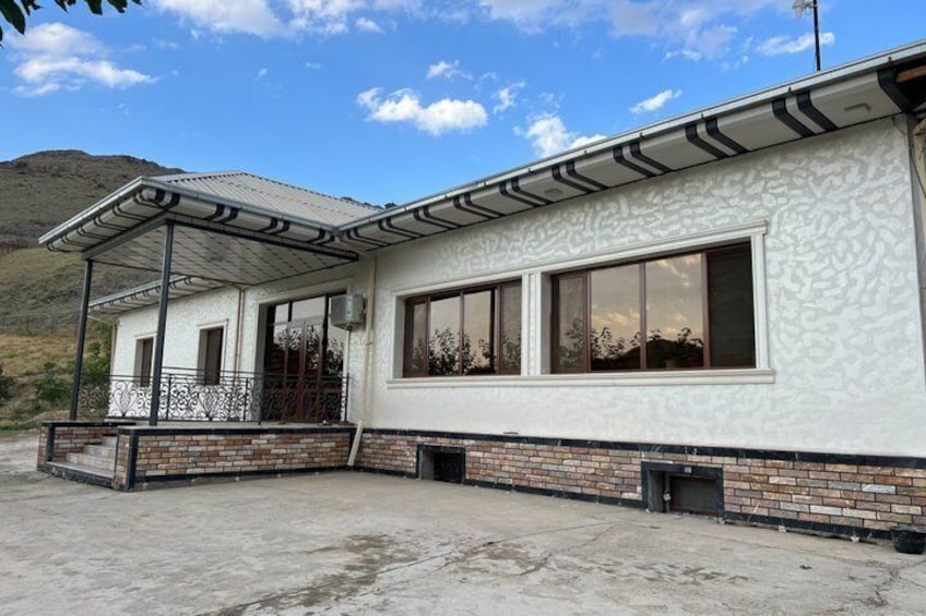 A two-story building with a covered porch, large windows, and a brick foundation. 3