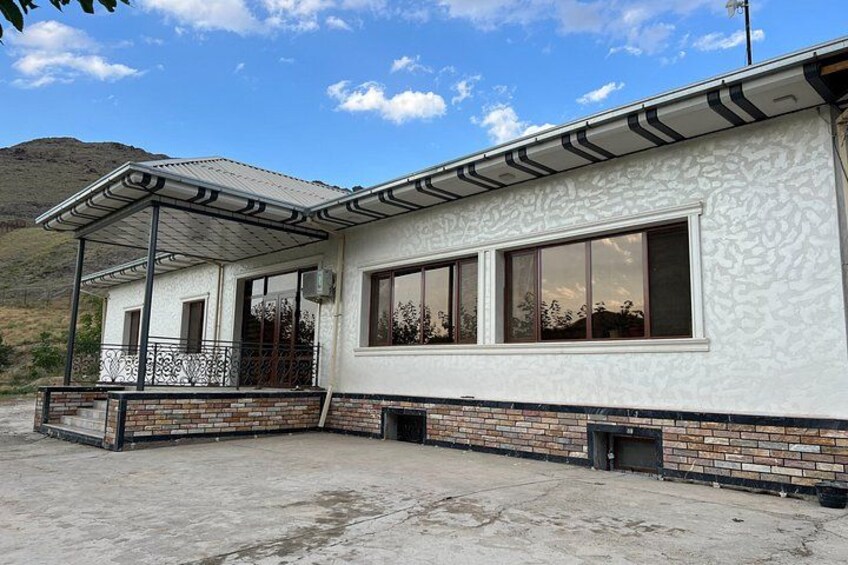 A two-story building with a covered porch, large windows, and a brick foundation. 3