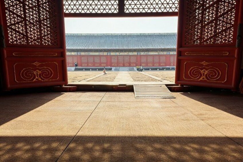 A traditional Japanese gate with a wooden floor leading to a courtyard. 3