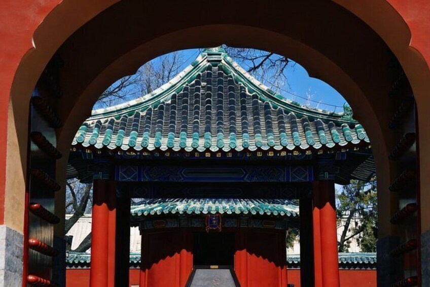 A traditional Korean gate with a tiled roof and red pillars. 4