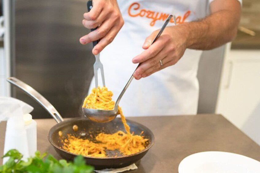 A person cooking spaghetti in a pan. 5