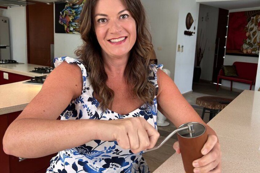 A person in a kitchen holding a measuring cup and a spoon. 3