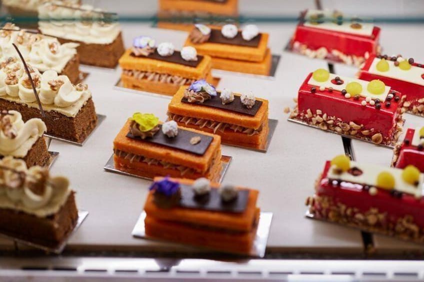 A variety of desserts on display, including cakes and pastries with different toppings and decorations. 2