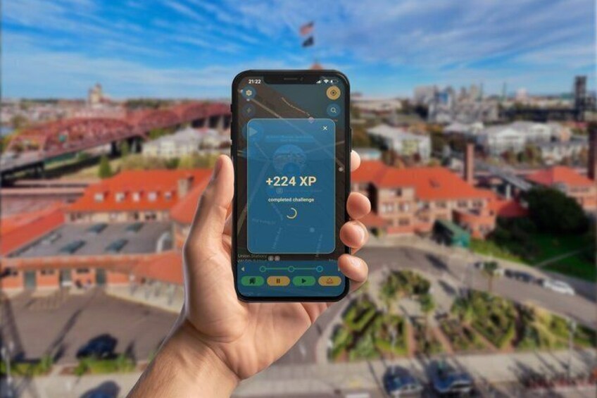 A hand holding a smartphone displaying a map with a completed challenge notification. 3