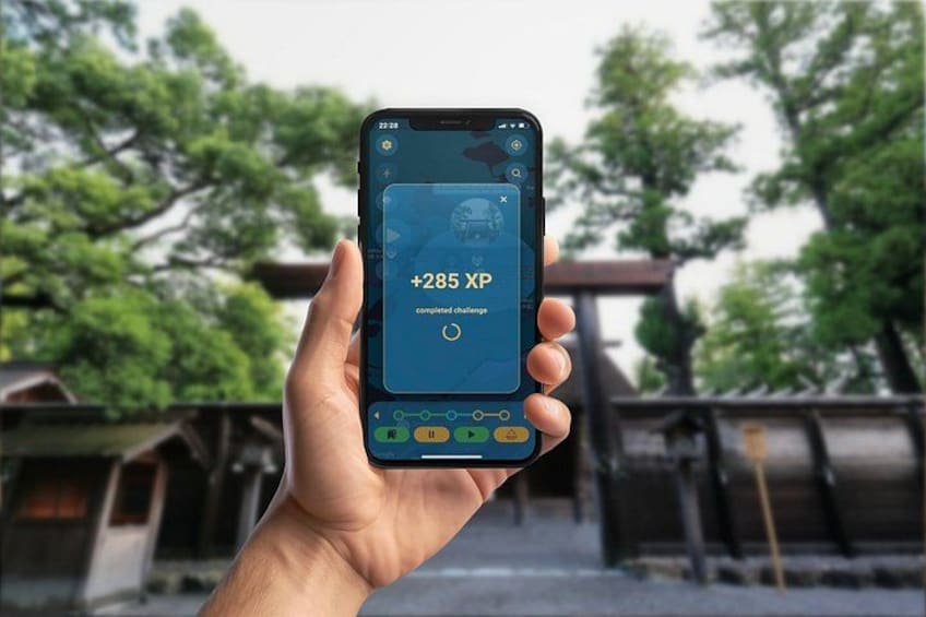A hand holding a smartphone displaying a game score of +285 XP. 5