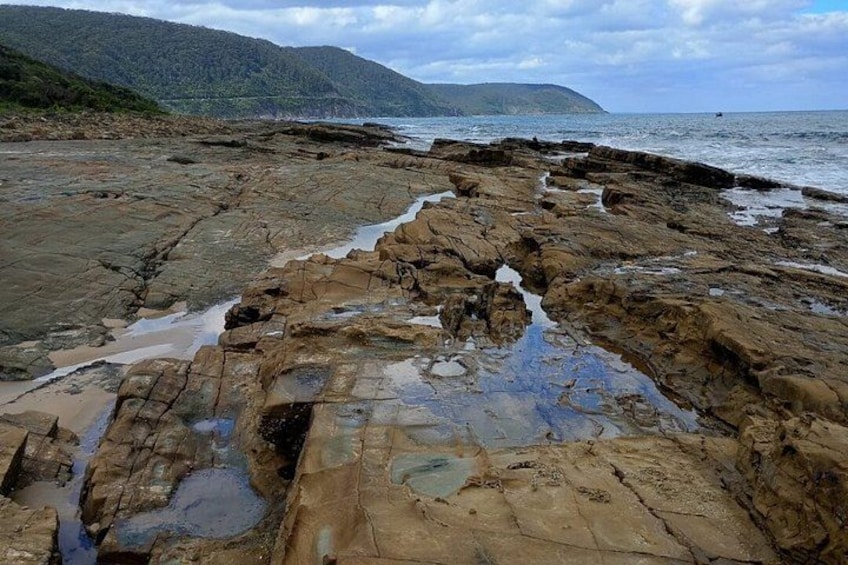 A rocky shoreline with water flowing through crevices. 3