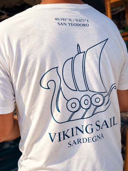 A white t-shirt with a Viking sail logo and the text 'VIKING SAIL SARDEGNA' on the back. 2