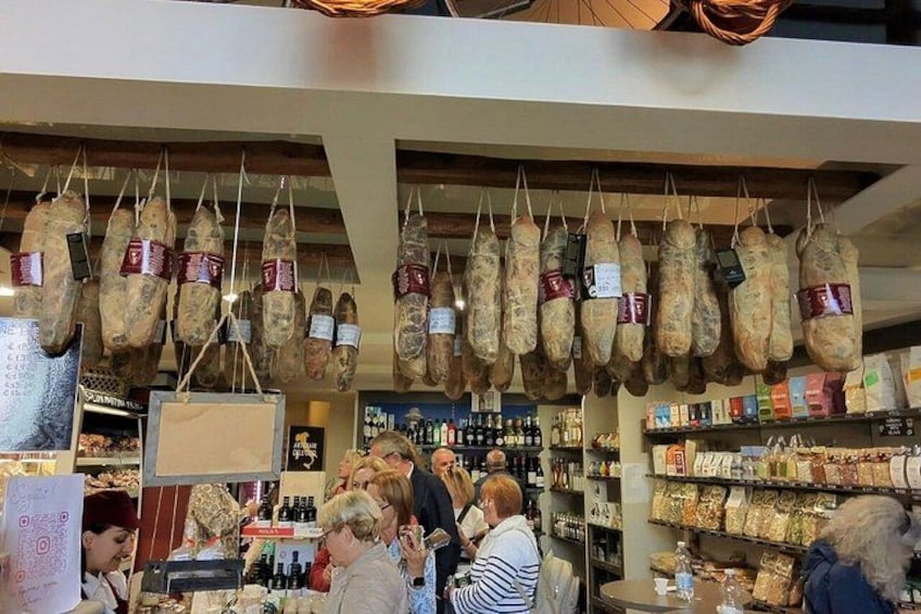 A market with hanging cured meats and shelves of packaged goods. 4