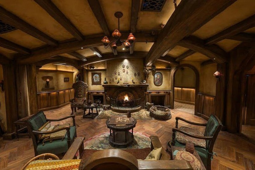 A rustic interior with a fireplace, wooden furniture, and a stone wall. 3