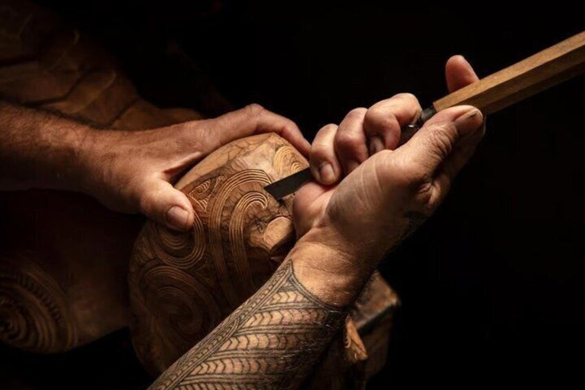 A person carving a wooden object with a chisel. 3