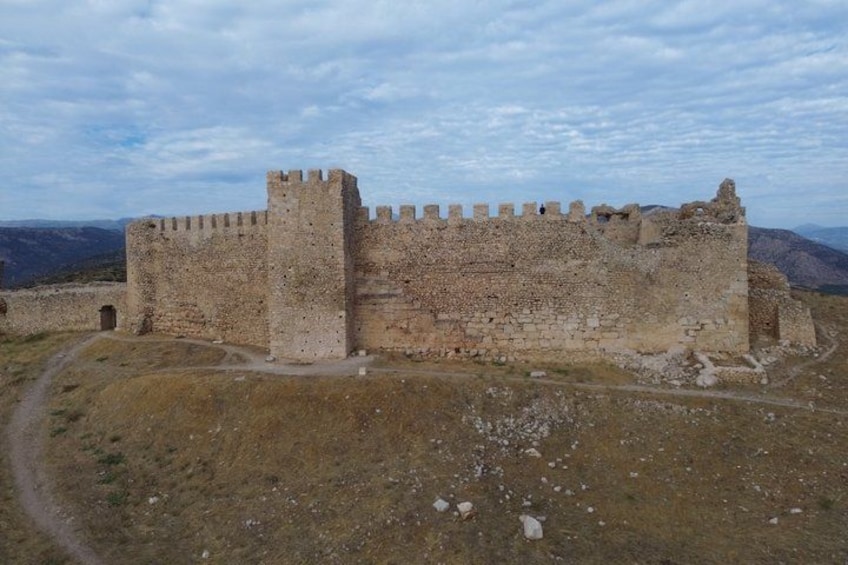 A large, historic stone castle with multiple towers and a surrounding moat. 2