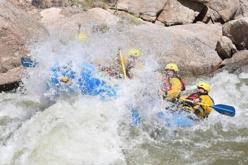 A group of people kayaking on a river surrounded by rocks. 4