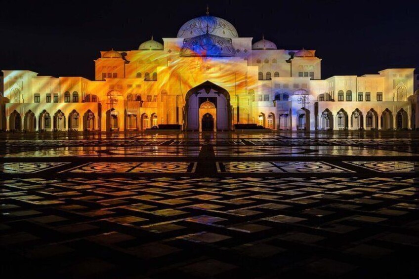 A building with a large dome and arched entrance, illuminated by colorful lights. 3
