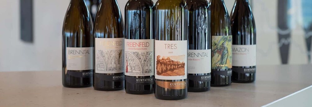 Several bottles of wine with labels, including 'Brennental' and 'FREIENFELD'. 1