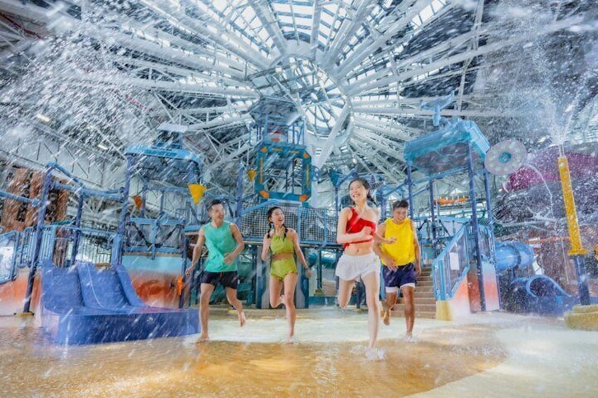 A water park with a large water slide and people enjoying the water features. 1