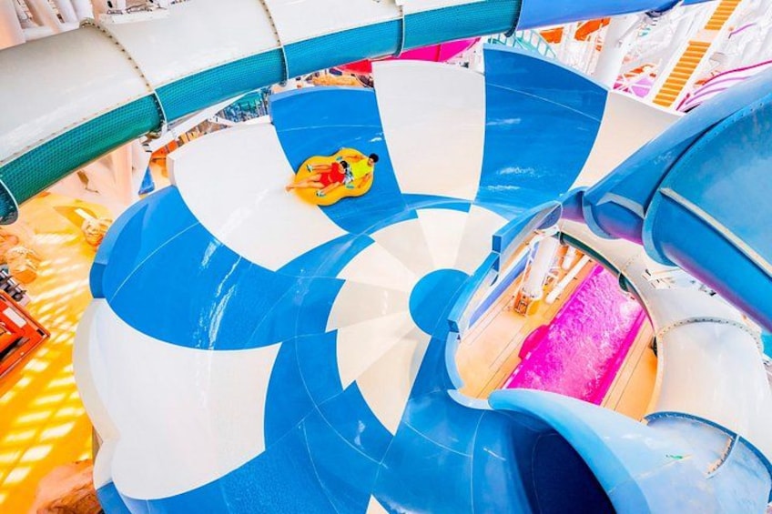 A water slide with blue and white sections, a yellow inflatable tube, and a pink water section. 4