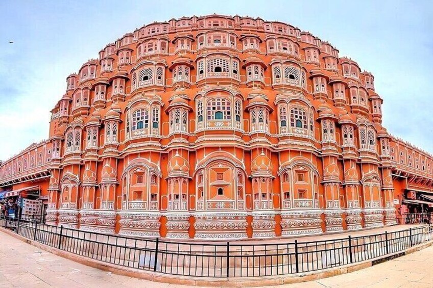 A large, ornate building with intricate architectural details and a surrounding fence. 5
