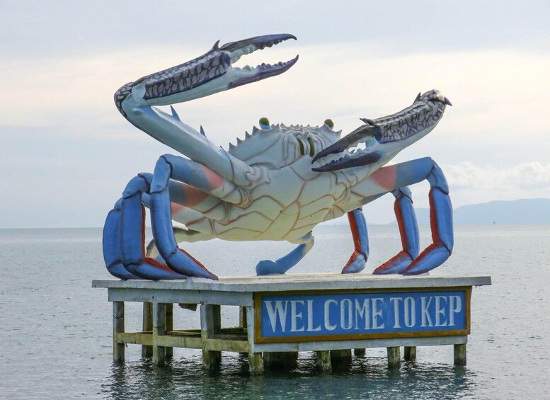 A large crab sculpture on a pier with a sign that reads 'WELCOME TO KEP'. 1