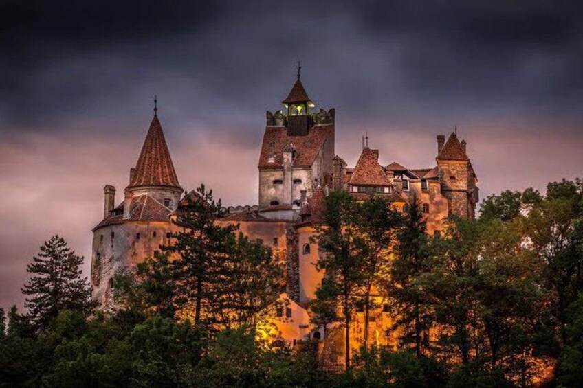 A historic castle with multiple towers, surrounded by dense forest. 4