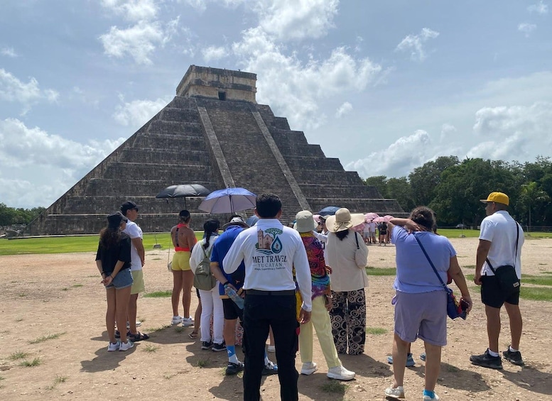 A group of people standing in front of a large pyramid structure. 3