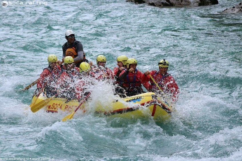 A group of people in a yellow raft navigating through turbulent water. 4