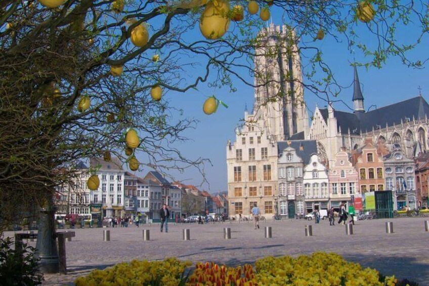 A historic building with a tall spire, surrounded by traditional European architecture. 2