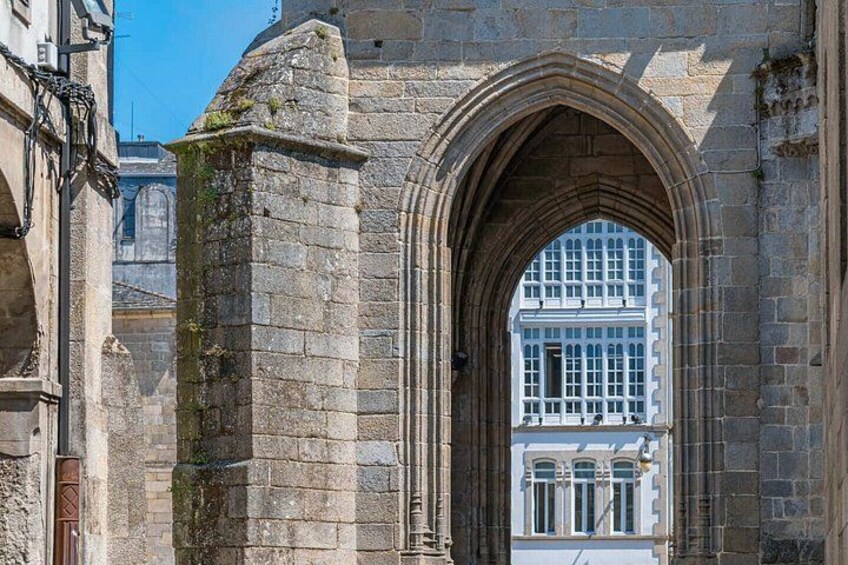A stone archway with a modern building in the background. 3